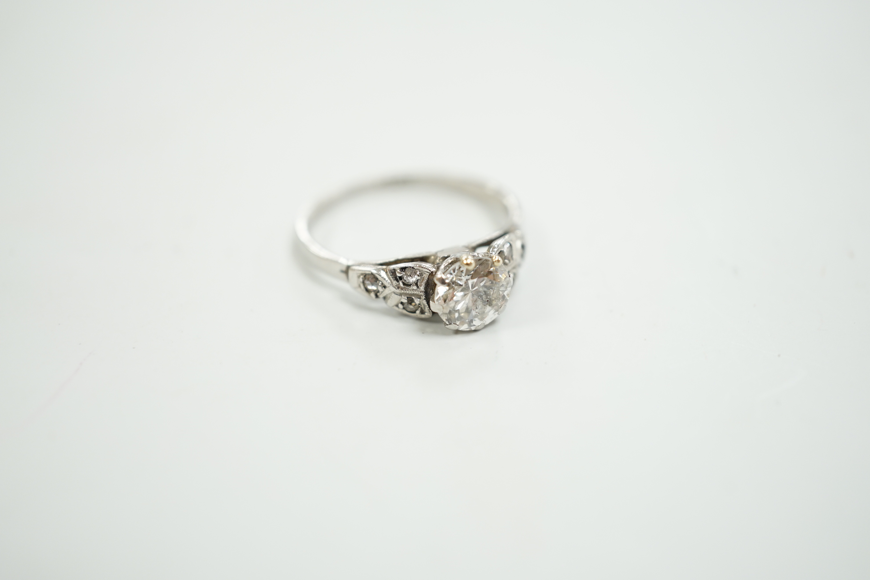 A white metal, stamped plat and single stone diamond ring, with diamond set shoulders, size O, gross weight 3.2 grams